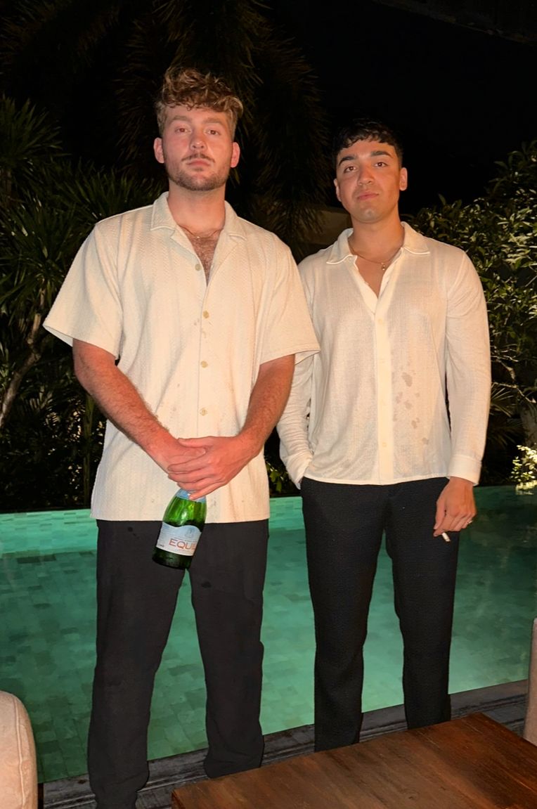 Nick and a friend by a pool at night in Bali, Indonesia