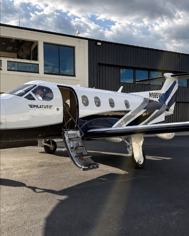 A Pilatus private plane parked outside a hangar