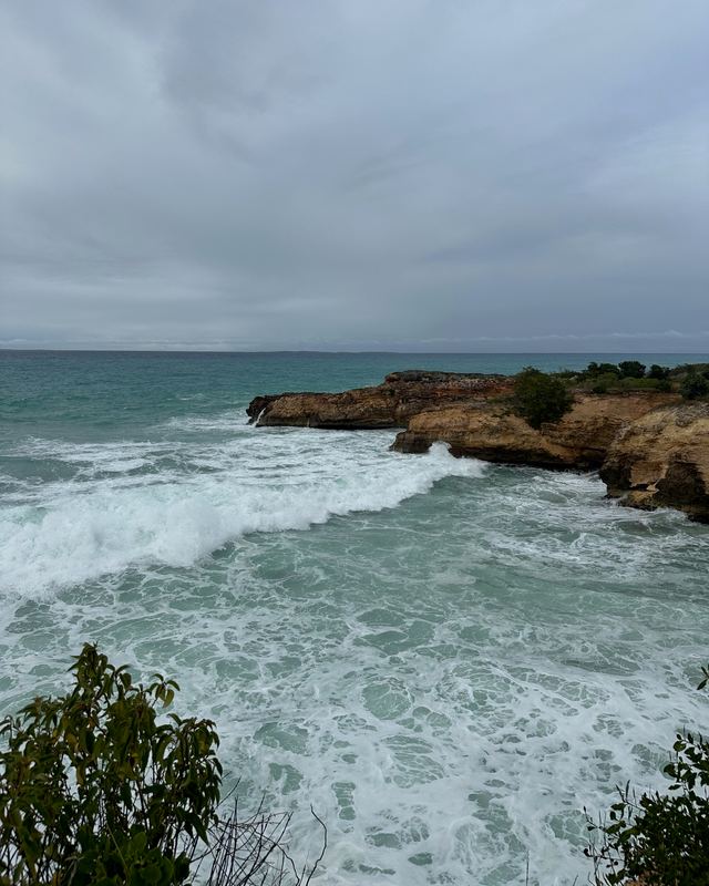 Waves breaking on a rocky coast under storm clouds in Anguilla